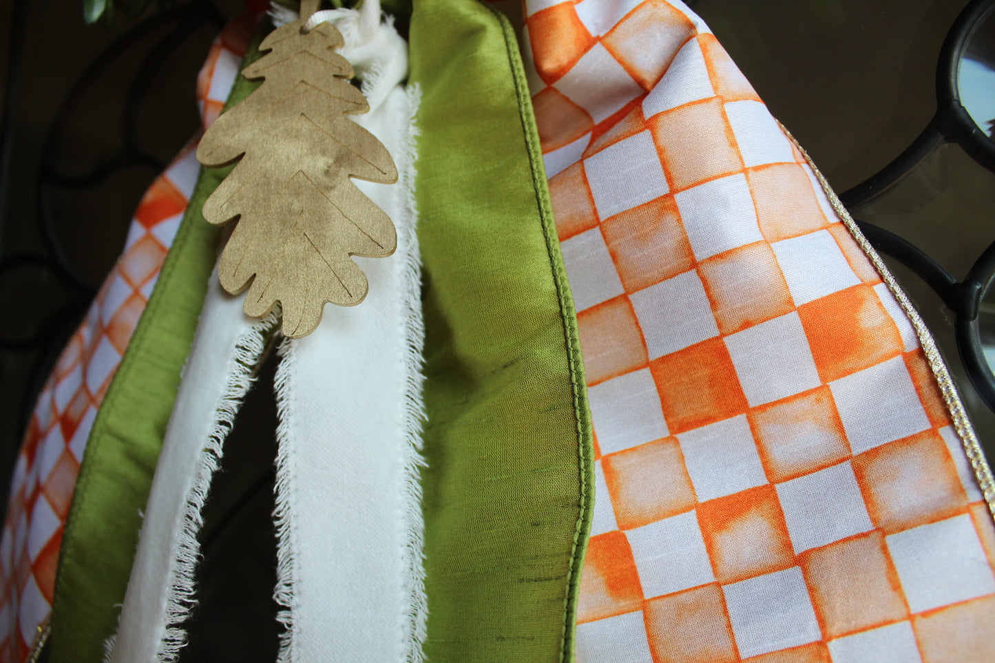 Close-up of a fabric with checkered pattern and leaf decoration.