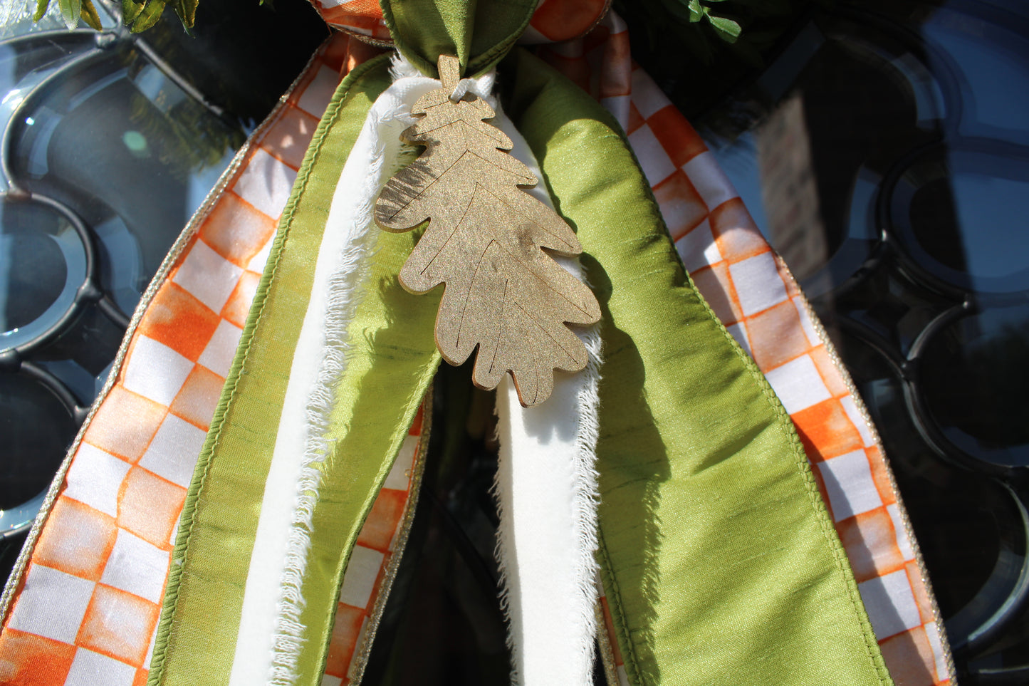 Decorative ribbon with green and orange pattern, featuring a leaf ornament.