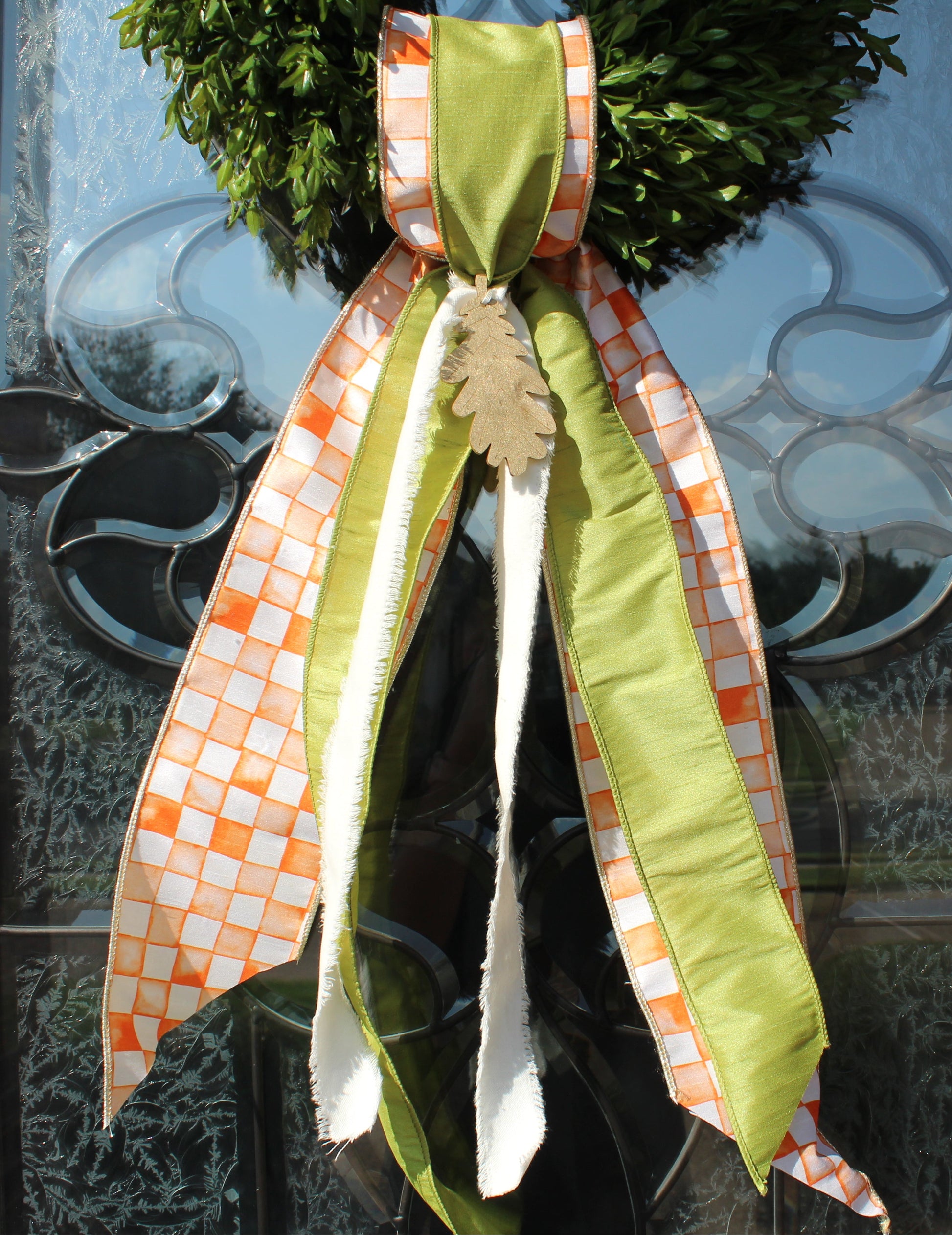 Decorative wreath with a green bow on a glass door